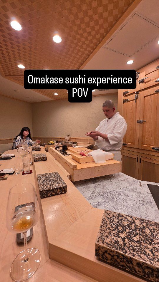 View from the seats of an omakase sushi counter with the chef at work