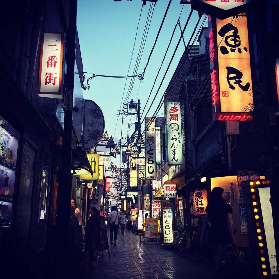 A neon-lit Tokyo alley at dusk